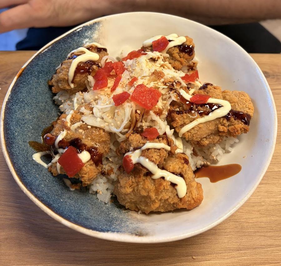Bol de poulet frit sur riz, sauce et oignons